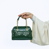 Main avec petit sac vert bandoulière courte