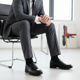 Rovan Noir - Chair Edge Sitting Leaning Forward Elbows Knees Charcoal Suit Proportional