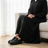 Woman in black djellaba sitting on sofa wearing 224F Balem slip-ons