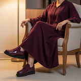 Woman in burgundy matte djellaba seated elegantly wearing 224F Balem Bordeaux slip-ons