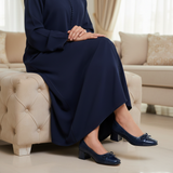 Woman in navy djellaba sitting on ottoman wearing 570F Nawar ballerinas