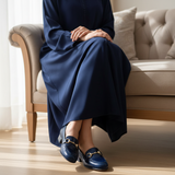 Woman in navy djellaba sitting on sofa wearing 738F Senflo loafers