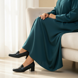 Woman in teal djellaba sitting gracefully wearing 157F Bayan loafers